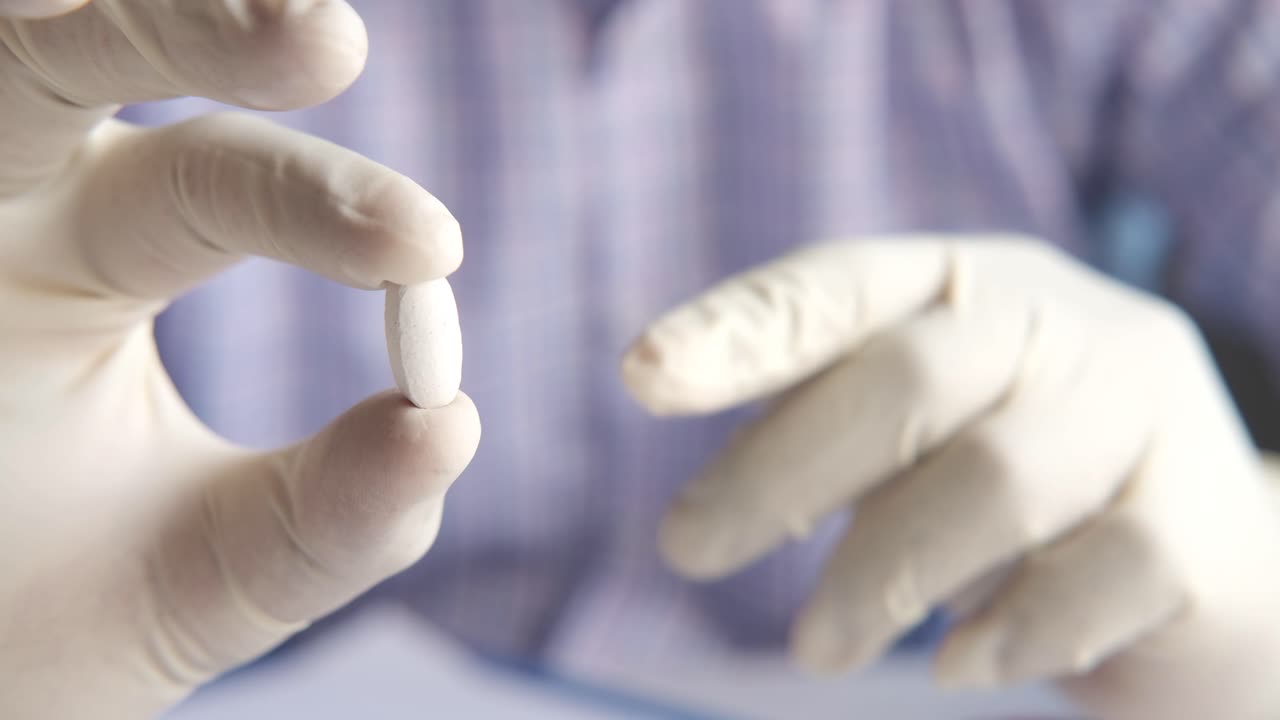 살균 장갑 을 착용 한 약 을 들고 있는 의사