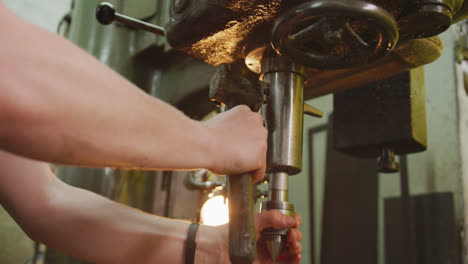 caucasian male hands factory worker at a factory standing at a workbench and operating machinery