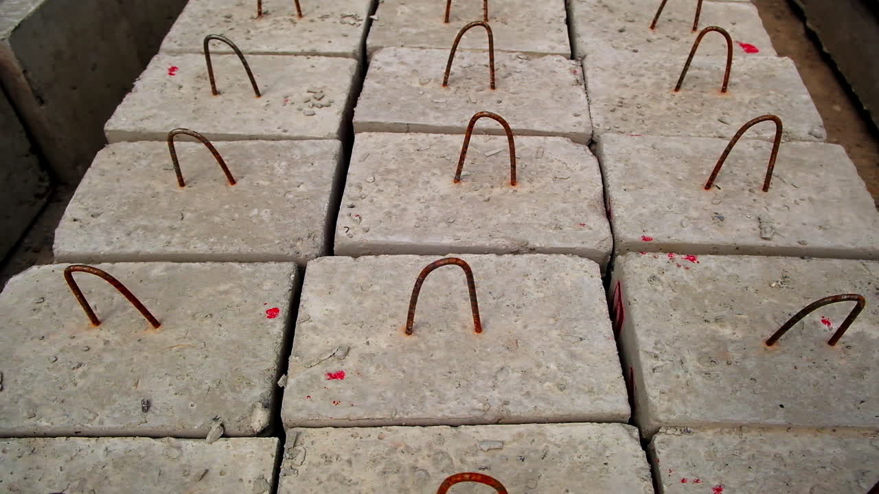 Armored concrete blocks with metal hinges on top. Ferroconcrete bricks left on the ground. View from top. Close up.