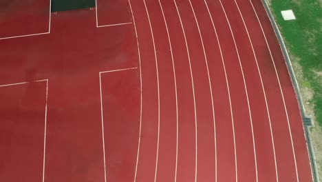 running track at the stadium, color is orange brick, high angle view by drone.