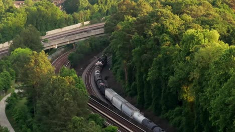 drone shot of railway freight trains and cars passing through georgia state route 400