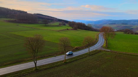 aerial view of bruchhausen an den steinen surrounded by beautiful landscape with cars driving on a small road during early morning light