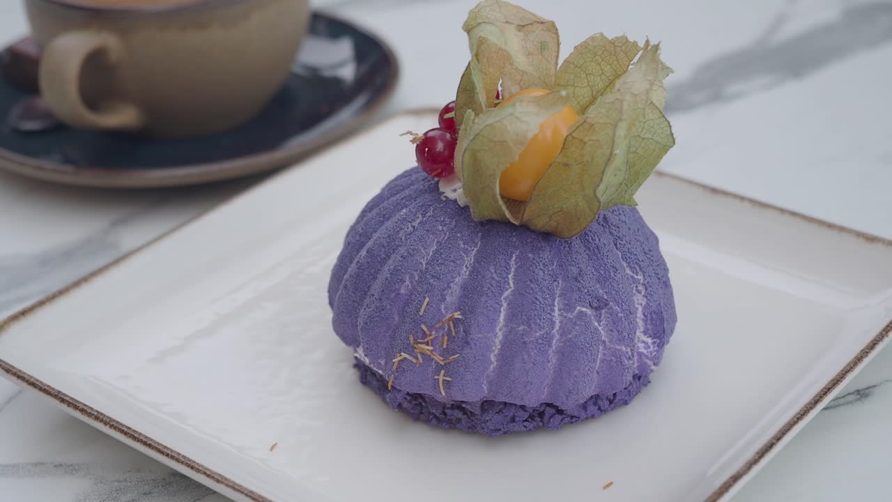 A dessert with a cape gooseberry and a cup of coffee