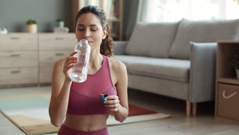 mujer deportiva bebiendo agua de botella