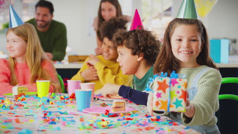 Chica-Dando-Regalos-En-La-Fiesta-De-Cumpleaños-Con-Amigos-Y-Padres-En-Casa.