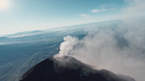 smokes rapidly burst from volcano peak in guatemala, aerial fpv view