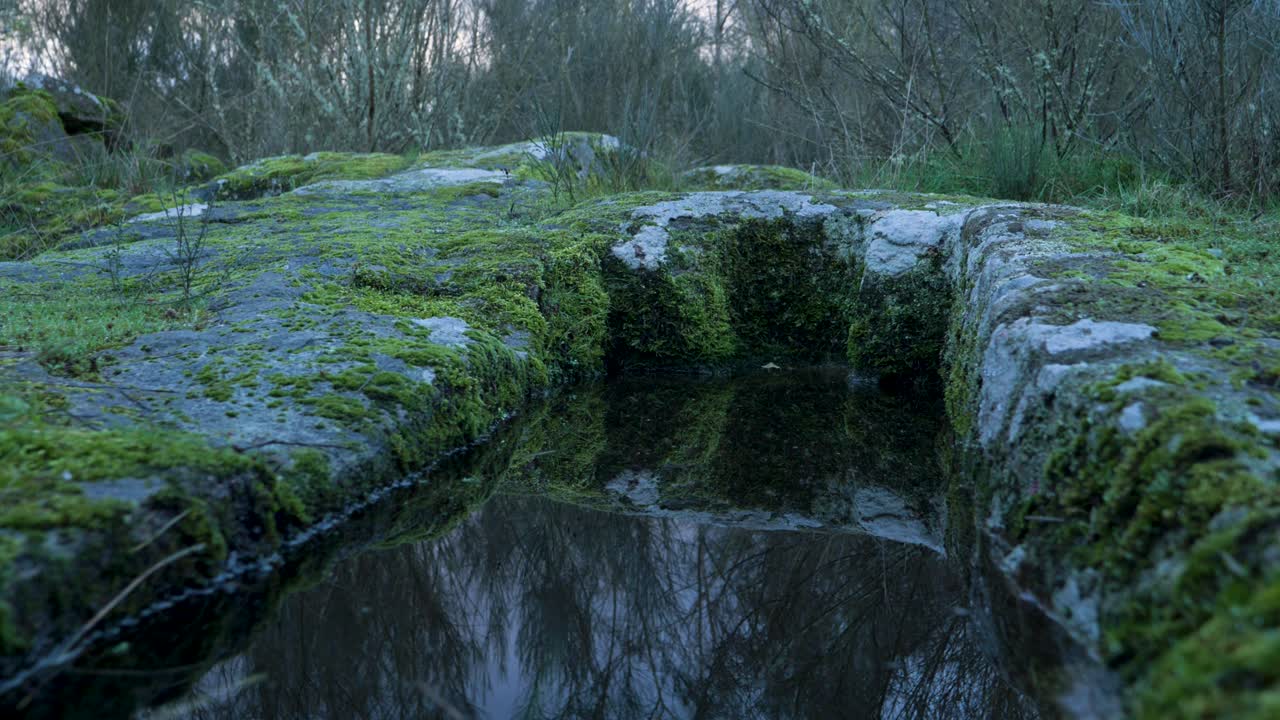 Low angle view of Anthropomorphic burial tombs reflection of rocks in water