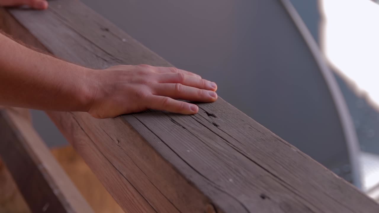 dos manos masculinas en una viga de madera de la baranda