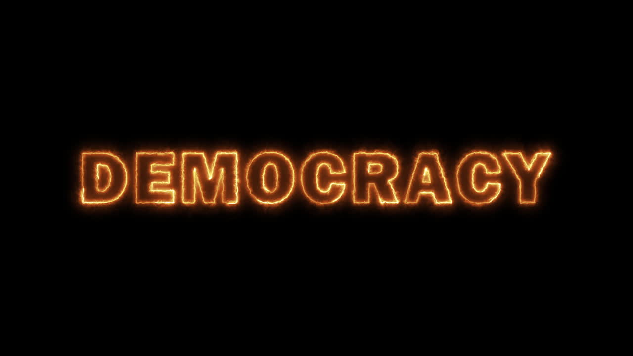 TEKSTEN DEMOKRATI med glødende ildskriftseffekt på sort baggrund. Perfekt til introer, dramatiske titler eller konceptuelle projekter, der handler om varme, lidenskab, mystik eller magi. Tema: Regering og politik.