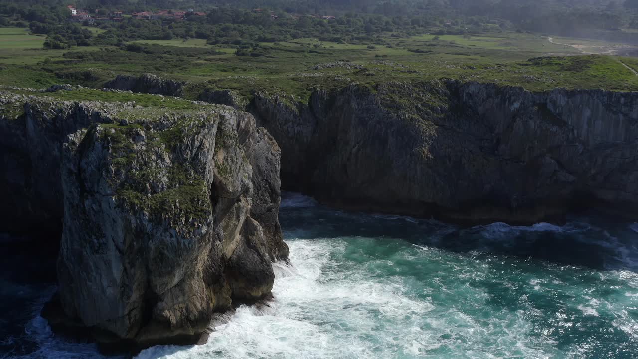 establecimiento aéreo estático de la caverna de bufones de pria en asturias, españa, mientras las olas del océano chocan contra rocas afiladas, en cámara lenta.