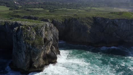 Statische-Luftaufnahme-Der-Höhle-Bufones-De-Pria-In-Asturien,-Spanien,-Während-Meereswellen-Auf-Scharfen-Felsen-Krachen,-Zeitlupe