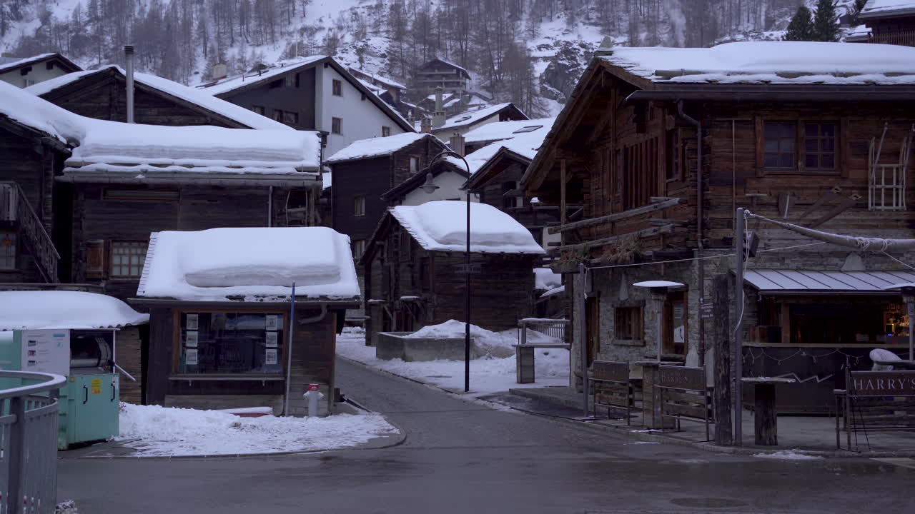 Tilt up from idyllic Swiss town to mountain peak covered by clouds