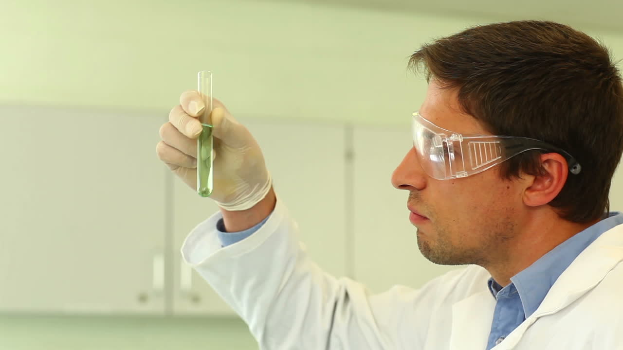 estudiante de ciencias enfocado examinando el tubo de ensayo