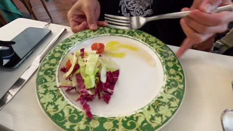 persona comiendo ensalada en un restaurante en milán