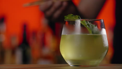 bartender preparing a refreshing cocktail with mint