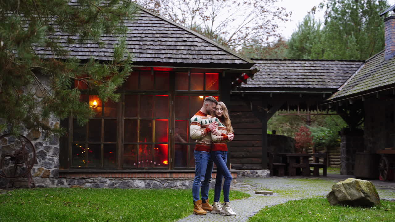 Romantic couple in the yard. Young guy and his girlfriend having a date on terrace in warm autumn day. Lovely couple stands at front yard of cottage.