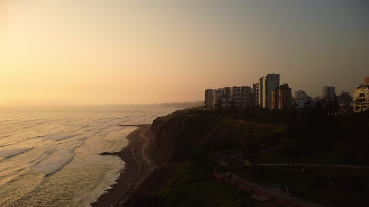vista aérea de los edificios costeros en la costa de la ciudad de lima, cielo nublado al atardecer