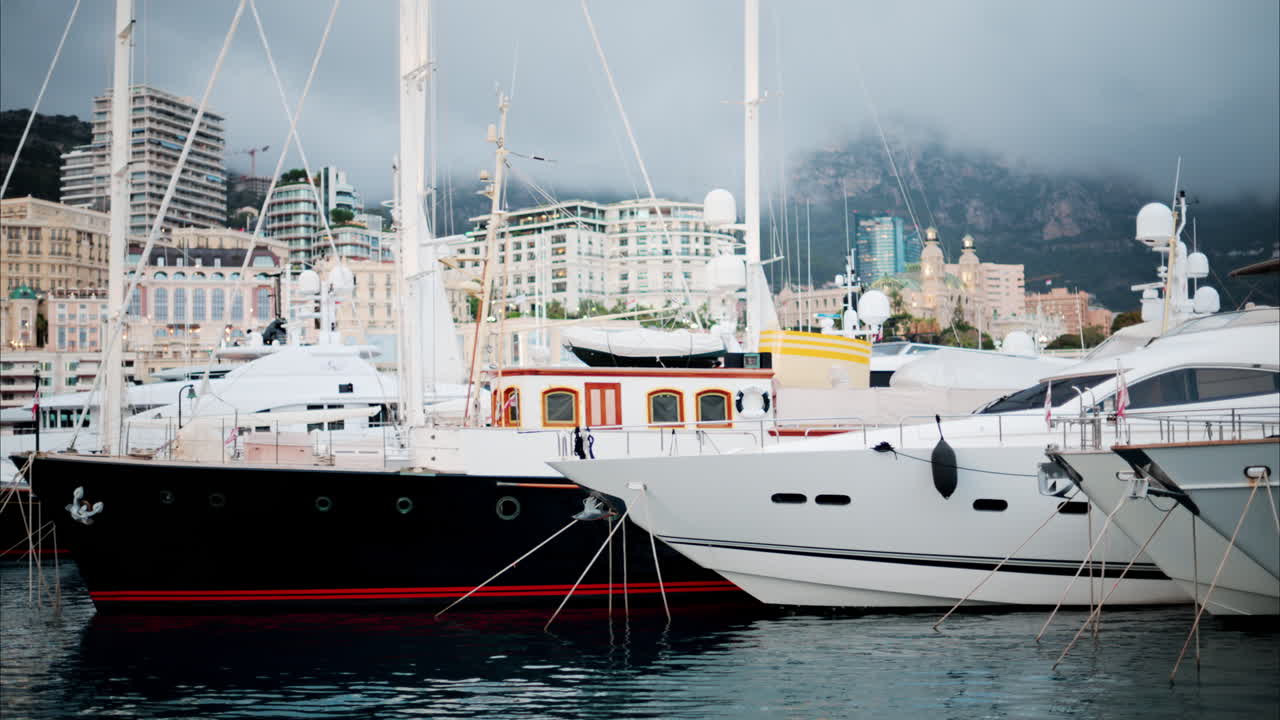 Vista delle barche ormeggiate nel porto turistico di Monaco con lo skyline della città sullo sfondo