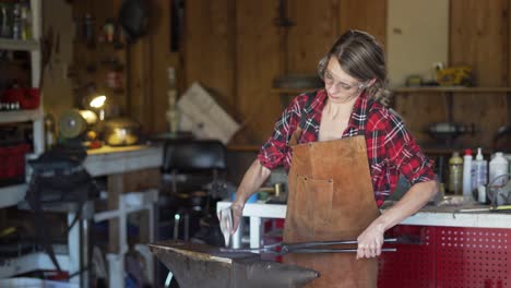 Still-Shot,-Young-Woman-in-Shop-Shapes-Metal-on-Anvil-with-Hammer