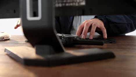 Security-guard-receiving-call-while-working-on-computer