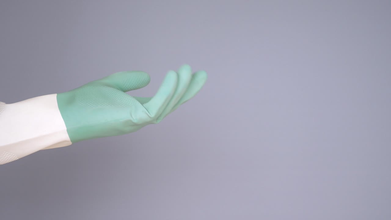 Person wearing green and white rubber cleaning gloves