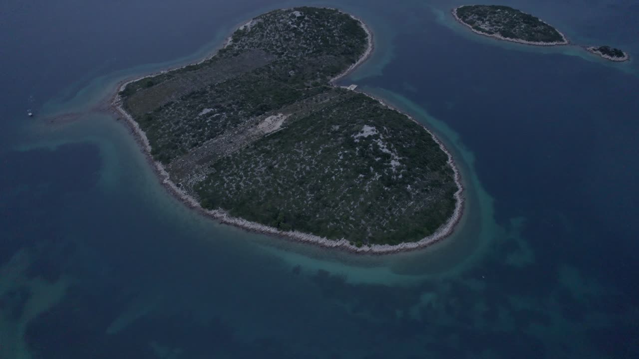 Herzförmige Liebesinsel umgeben von Meer- und Sonnenuntergangsfarben, Kroatien