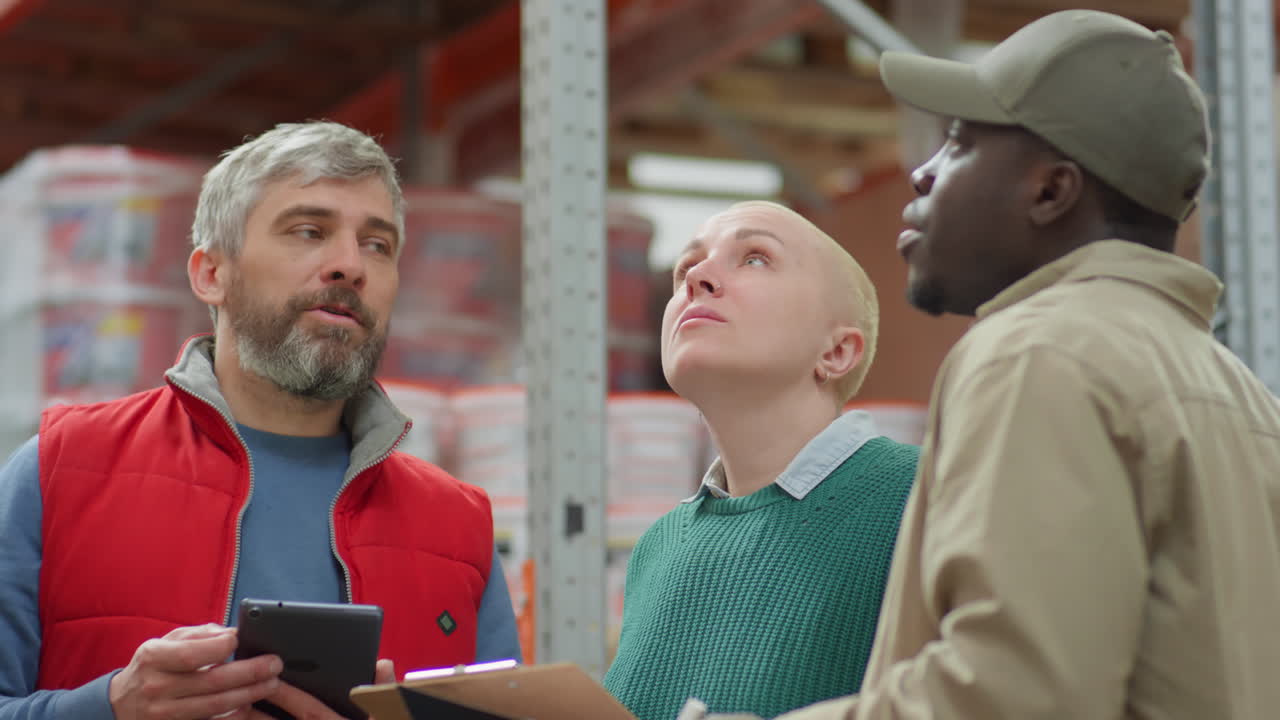Warehouse Staff Inspecting Inventory and Discussing Operations