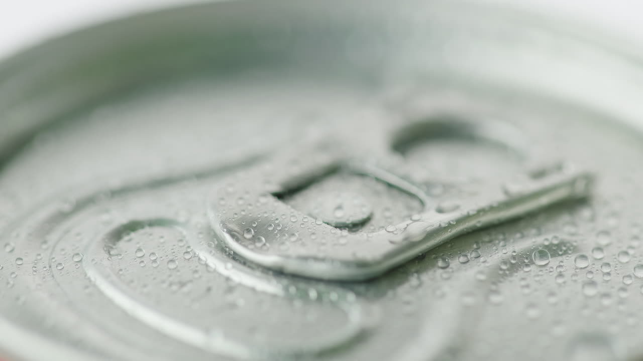 炭酸飲料のアルミ缶の蓋は、凝縮液の滴で覆われています。