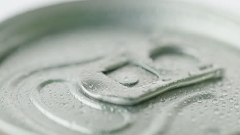 the lid of the aluminum can from the carbonated drink is covered with droplets of condensate cool dr