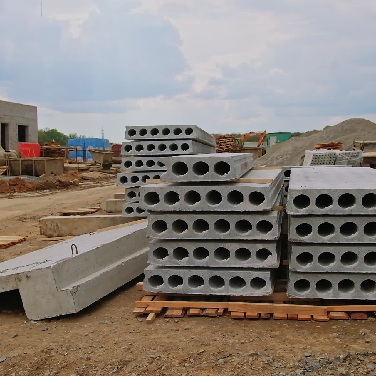 New house of bricks building site. Piles of grey blocks on the ground. Cranes working at backdrop