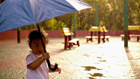 baby holding umbrella in the park