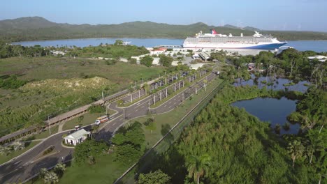 aerial view of entrance at amber cove cruise park terminal with parking cruise ship in background - puerto plata,spain