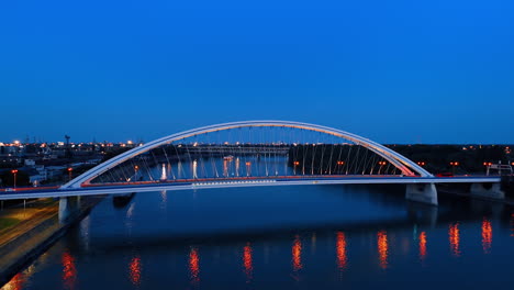 dusk time in bratislava, slovakia. footage over the danube near the appolo bridge with street lights on