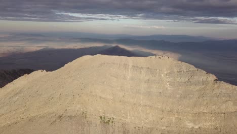 hikers-at-the-top-of-mt-nebo-in-salt-lake-city-Utah-with-dramatic-golden-hour-light-casting-over-the-landscape---AERIAL-DOLLY