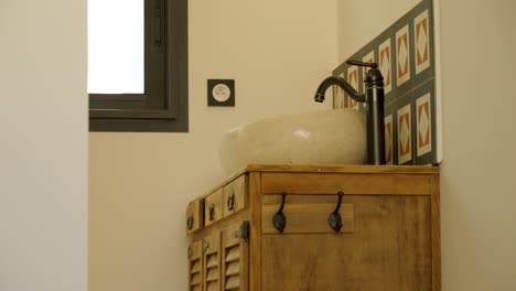 slow revealing shot of an antique bathroom with a sink on a wooden cabinet