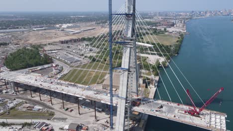 Industrial-machines-building-international-Gordie-Howie-bridge-in-Michigan,-aerial-view