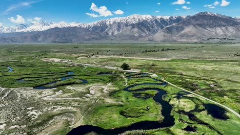 Luftaufnahme-Des-Owens-River,-Der-Nach-Einem-Großen-Winter-In-Der-Sierra-Nevada-Durch-Das-Grüne-Tal-Fließt