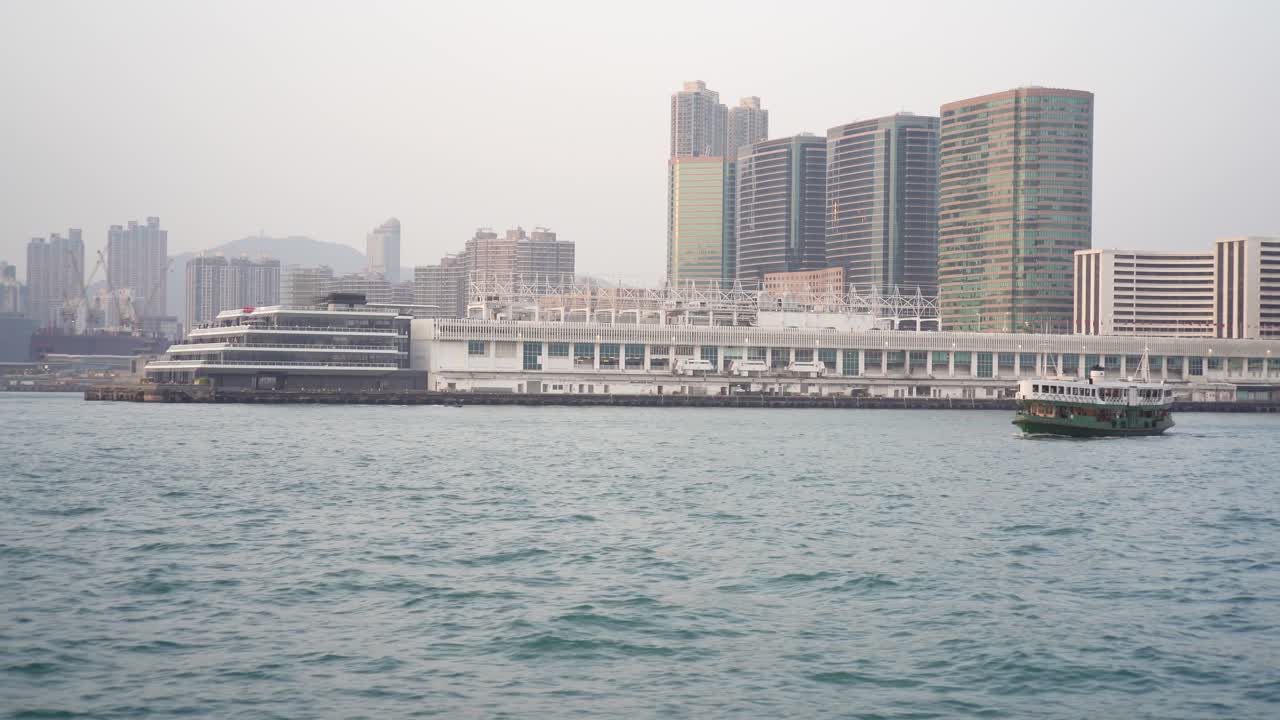 View Of Ocean Terminal With Ferry Boat Sailing Past In Victoria Harbour In Hong Kong