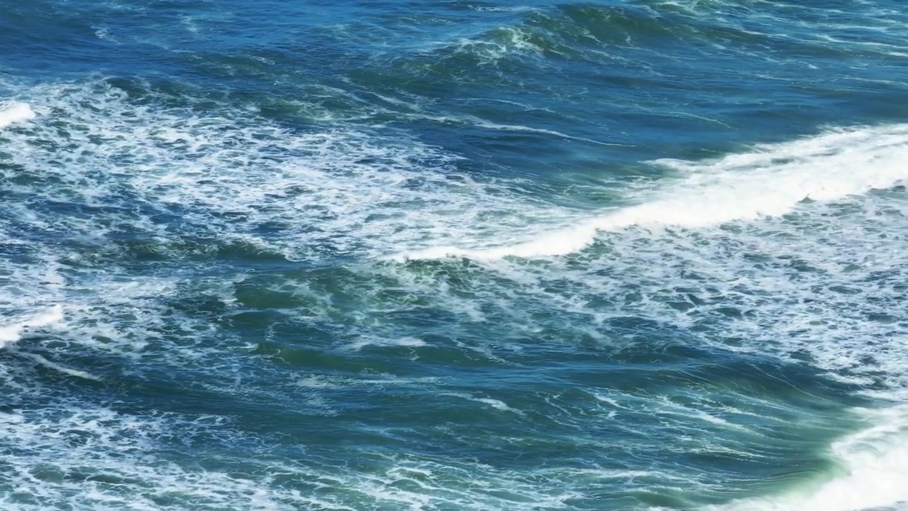 Vue aérienne d'une plage de sable le long de la côte atlantique au Portugal. Les vagues de l'océan s'écrasent sur le rivage. Des dunes côtières et des eaux bleues s'étendent à l'horizon.