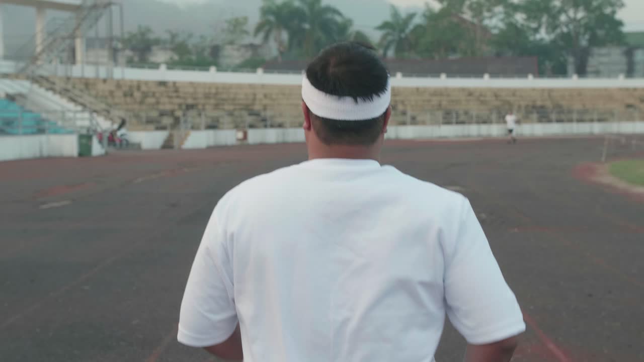Back Of Overweight Man Jogging At Stadium