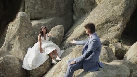 Groom-with-bride-sit-on-a-slope-of-the-mountain.-Wedding-couple.-Happy