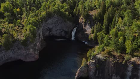 Luftaufnahme-Eines-Versteckten-Wasserfalls,-Umgeben-Von-Dreien