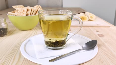 green tea with jasmine is brewed, leaves move in cup