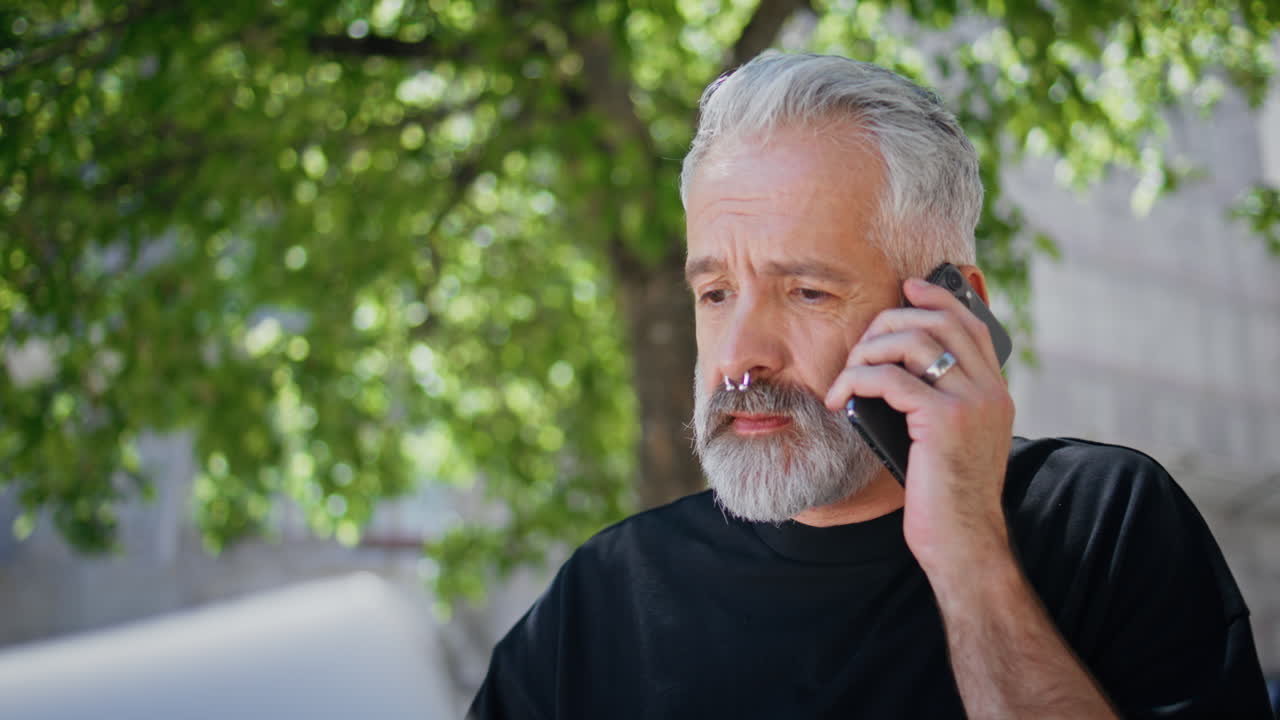 Mature businessman making call in city park closeup. Cafe owner hold coffee cup