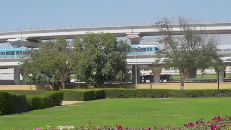 dubai metro train with traffic on highway from empty park of al rashidiya in dubai, united arab emirates