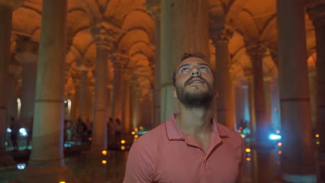 tourist looking at columns in indoor historical place.