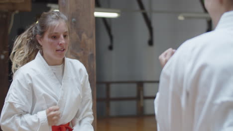 handheld shot of focused girl fighting with her opponent in gym