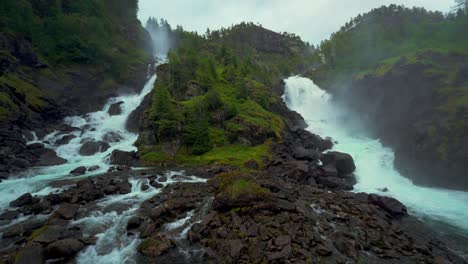 latefossen twin waterfall, norway. idyllic scenic cascade in scandinavia nature, lush green landscape.