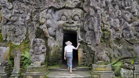 Journey-into-Mystery:-Male-Tourist-dressed-in-traditional-Balinese-Sarong-Explores-Goa-Gajah-Elephant-Cave,-one-of-the-holiest-temples-in-Ubud,-Bali