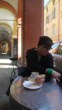 person having coffee and bread in a cafe